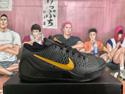 Side view of a black basketball sneaker with a gold Nike Swoosh, textured upper, black laces, and layered black outsole.
