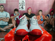 Front view of the grey Nike sneakers showing white laces, red toe panels, and red outsole sections.