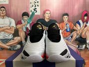 Front view of white basketball shoes with black laces and patterned detailing