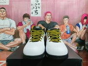 Front view of white Nike basketball shoes with black and gold patterned laces