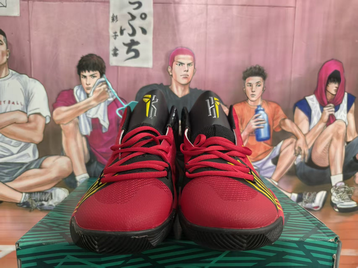 Front view of red, black, and yellow Nike basketball-style sneakers with red laces and black outsoles.