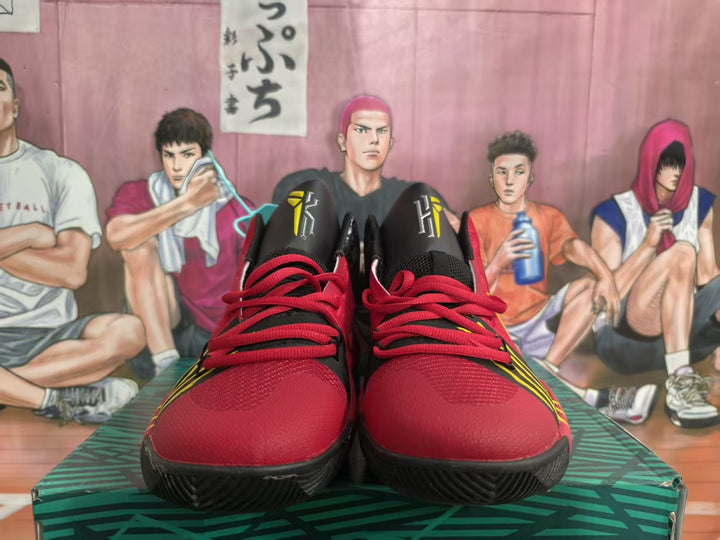 Front view of red, black, and yellow Nike basketball-style sneakers with red laces and black outsoles.