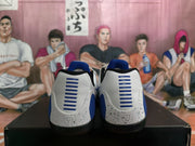 Rear view of the white and blue basketball sneakers showing blue heel details, black collars and black outsoles.