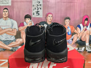 Rear view of black Nike high-top sneakers showing the heel swooshes and chunky layered soles on a Nike box.