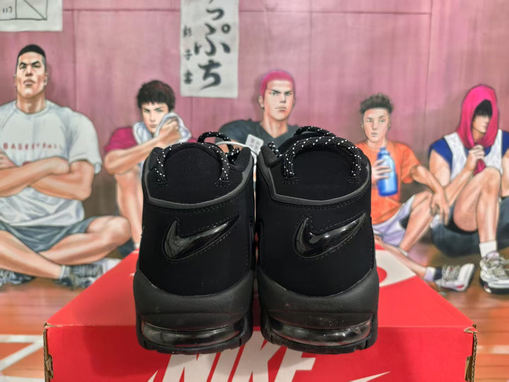 Rear view of black Nike high-top sneakers showing the heel swooshes and chunky layered soles on a Nike box.