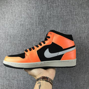 Opposite side view of the black, orange and grey Air Jordan 1 Mid sneaker.