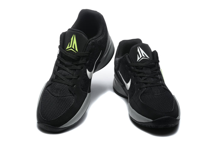 Pair of black Jordan sneakers shown from the front, with white and bright yellow tongue and side accents.
