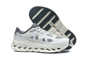 White and grey On Cloudtilt Remix sneakers shown from the side and underneath