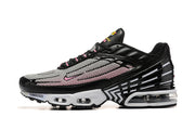 Side profile of a black, white, and pink Nike Air Max Plus sneaker.