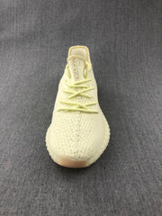 Front view of the pale cream sneaker showing tonal laces and the textured knit-style upper.