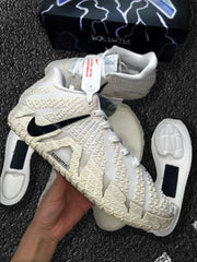 Close-up of an off-white Nike sneaker showing the textured upper, black Swoosh, laces, and sole components.