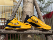 Side views of the shoes, showing yellow uppers and black midsole accents.