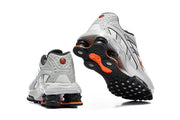 Nike Shox Ride 2 sneakers viewed from the heel and outsole, showing black and orange sole details.