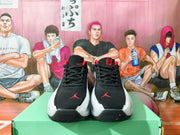 Front view of black Jordan shoes with white side panels and red details