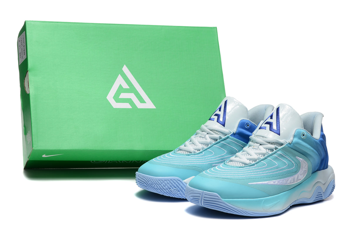 Aqua-blue and white Nike basketball shoes beside a green shoebox