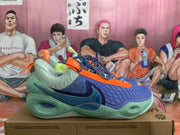 Side view highlighting the blue upper, green sole, orange accents, and Nike Swoosh.