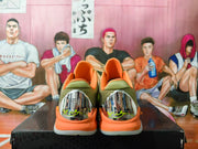 Rear view showing reflective-looking heel panels and orange collars on the basketball shoes.