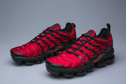 Pair of red and black Nike TN sneakers shown from the front and side.