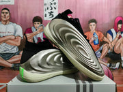 Side view showing sculpted silver panels, black collar, and cream-colored sole.