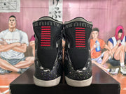 Rear view showing black knit collars, red heel accents, graphic side panels, and speckled detailing near the midsoles.
