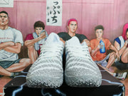 Pair of white and gray low-top basketball shoes shown from the front, with textured uppers and patterned outsoles.
