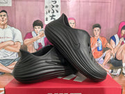 Angled view of black slip-on clogs showing the perforated toe and sculpted sidewalls.