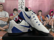 Angled view of the white and blue Nike basketball sneakers showing the Swoosh, lacing system, blue accents and speckled midsole details.