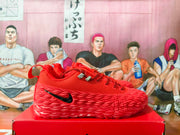 Side view of a red Nike basketball shoe with black Swoosh and textured sidewall.
