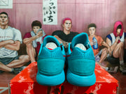 Rear view of the blue sneakers showing padded collars, embossed NIKE heel branding, and ribbed outsoles.