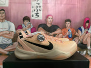 Side view of a peach-colored basketball shoe with black Swoosh detailing and heel graphics.