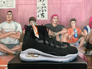 Side view showing the black upper, lace-up closure, white sole, and gold-tone emblem.