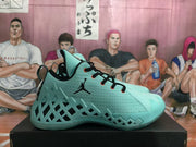 Side profile of a green Jordan basketball sneaker showing the textured upper, black Jumpman logo, and geometric side cutouts.