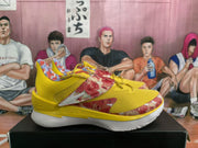 Side profile of a yellow basketball shoe with red floral print and white sole