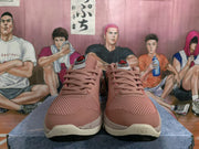 Front view of the pink sneaker pair showing matching laces, textured toe panels, and graphic tongue labels.