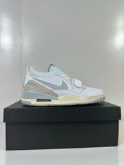 Single Jordan Legacy 312 Low sneaker in side profile, showing the silver Swoosh, patterned heel panel, and visible heel cushioning window.
