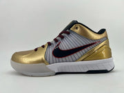 Side profile of the gold, white, and black sneaker with red accents.