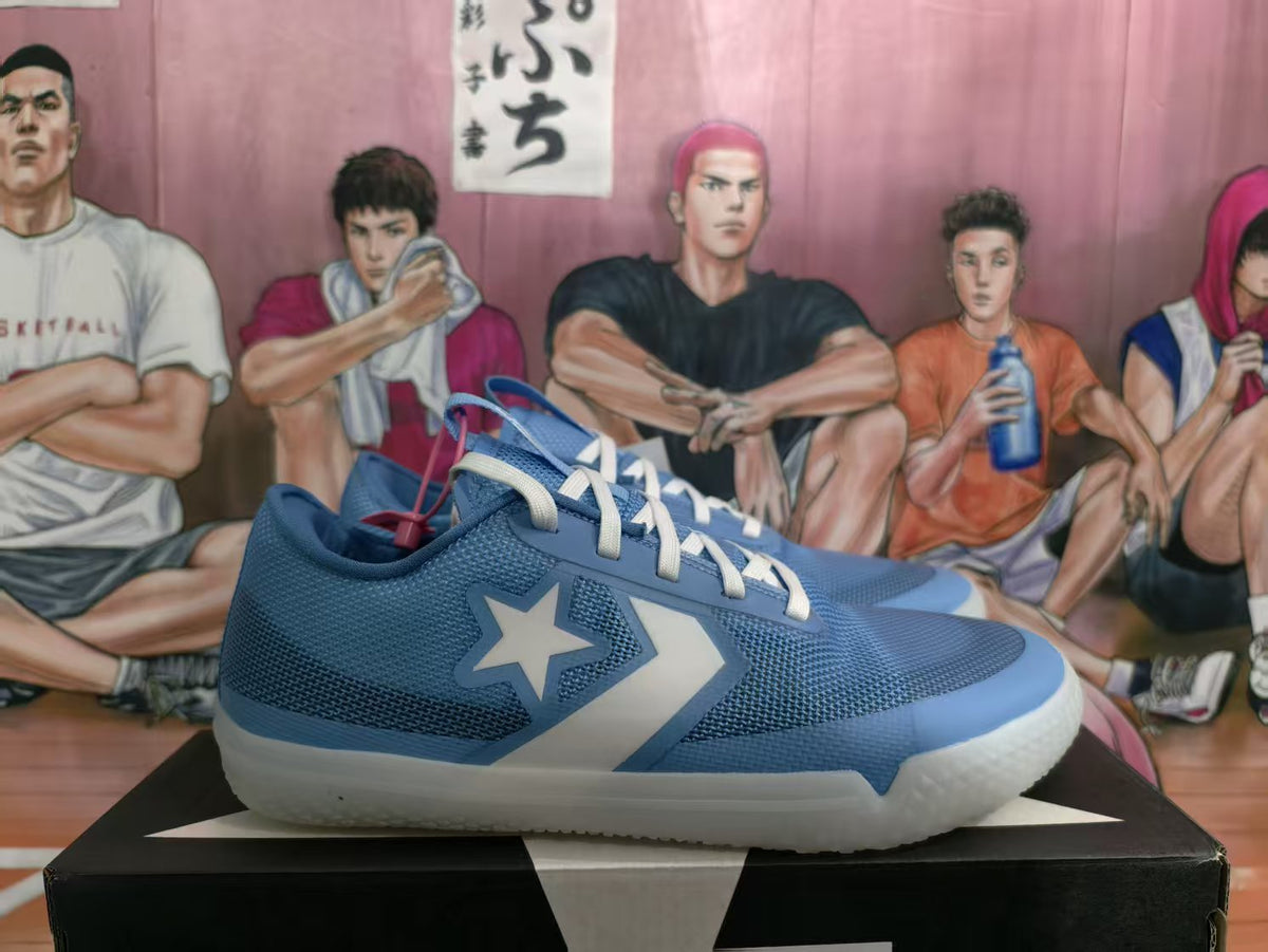 Blue basketball sneakers with white laces and star-and-chevron side details displayed on a shoebox.