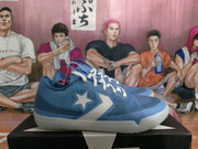 Blue basketball sneakers with white laces and star-and-chevron side details displayed on a shoebox.