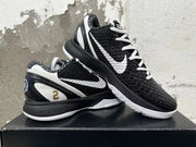 Pair of black and white Nike basketball shoes showing the patterned upper, white Swoosh, and contrasting soles