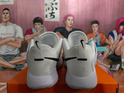 Rear view of white Nike basketball sneakers with black heel Swoosh logos on an orange shoebox.