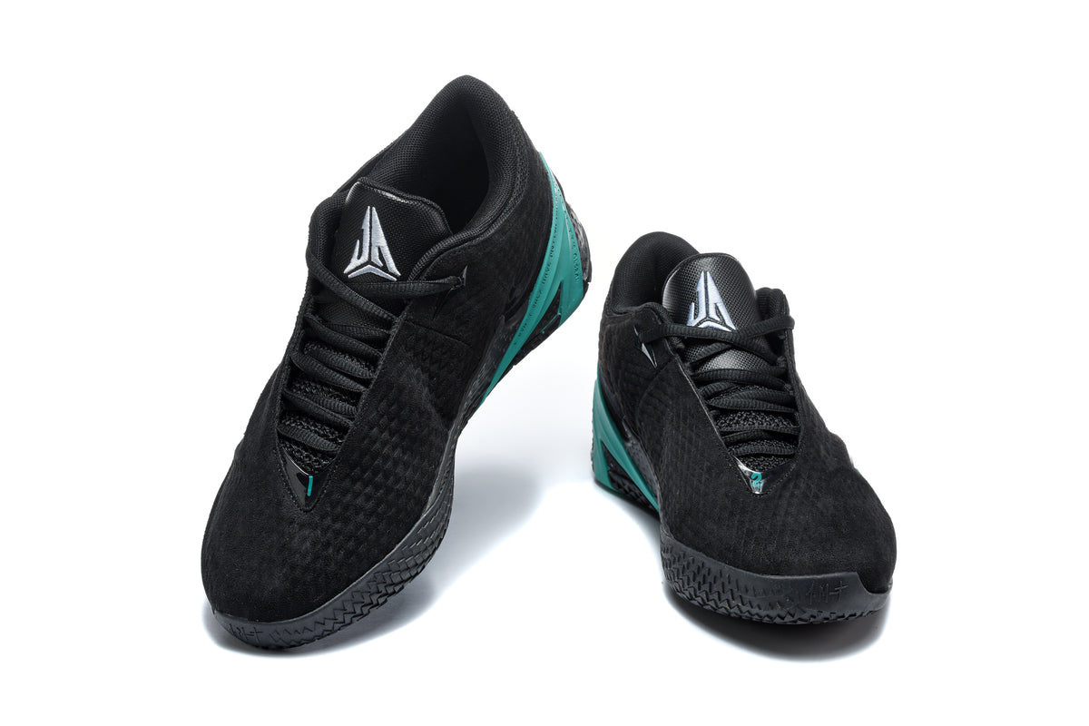 Pair of black low-top basketball shoes with green accents, shown from the front