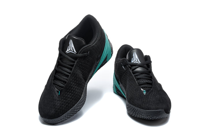 Pair of black low-top basketball shoes with green accents, shown from the front
