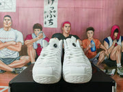 Front view of white high-top sneakers displayed on a black shoebox.