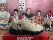 Side profile of a beige Nike Air Max sneaker with a black Swoosh and sculpted black outsole.
