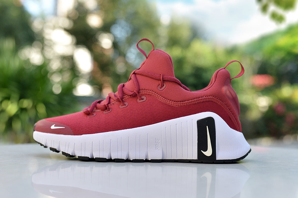 Side view of a red Nike low-top sneaker with a thick white sole and black heel accent