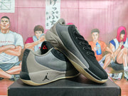 Angled view of the black and grey Jordan sneakers with one shoe resting on the other.