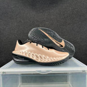 Pair of metallic pink basketball sneakers showing the outsole traction pattern and Nike branding.