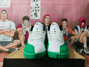 Front view of white and green Jordan high-top sneakers with Jumpman tongue logos