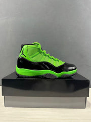 Side profile of a black and vivid green sneaker displayed on a black box.