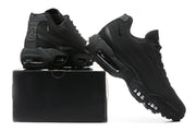 Black Nike sneakers displayed beside a black shoe box, with side panels and visible air units in view.